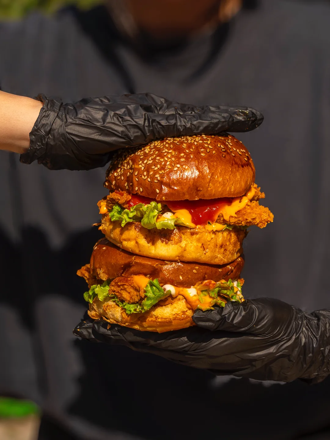Siyah eldivenli elde iki katlı burger